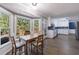 Bright kitchen with wood floors, white cabinets, dining area and view to the exterior deck through large windows at 6507 Bennington Dr, Tucker, GA 30084