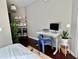 Bedroom featuring a modern desk with a blue chair, plants, hardwood floors, and a neutral color scheme at 800 Peachtree Ne St # 8415, Atlanta, GA 30308