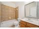 Tiled bathroom featuring a bathtub, shower, toilet, mirror, and vanity with sink at 1151 Nash Lee Sw Dr, Lilburn, GA 30047