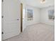 A bright, carpeted bedroom is shown with two windows letting in light at 1151 Nash Lee Sw Dr, Lilburn, GA 30047