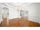 Elegant dining room features hardwood floors, classic wainscoting, arched doorways, and chandelier at 1151 Nash Lee Sw Dr, Lilburn, GA 30047