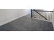 Upstairs hallway featuring gray carpet, white brick accent wall, and dark metal railing at 263 Auburn Valley Way, Auburn, GA 30011