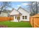 Spacious backyard featuring a well-maintained lawn, wood fence, and a covered patio area at 395 W Lake Nw Ave, Atlanta, GA 30318