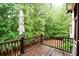 View of the wooden deck with lush trees surrounding the outdoor space at 160 Edgewater Trl, Fayetteville, GA 30215