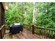 View of the spacious wooden deck with lush greenery surrounding the outdoor grill at 160 Edgewater Trl, Fayetteville, GA 30215