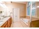 Bright bathroom featuring a soaking tub, double vanity, and tiled accents at 160 Edgewater Trl, Fayetteville, GA 30215