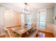 Bright dining room featuring a wooden table, wainscoting, and modern light fixture at 160 Edgewater Trl, Fayetteville, GA 30215