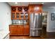 Well-equipped wet bar features beautiful wood cabinetry, a wine rack and a stainless-steel refrigerator at 160 Edgewater Trl, Fayetteville, GA 30215