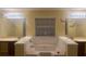 Elegant bathroom with a soaking tub between two vanity sinks with mirrors and butterfly decorations at 4312 Defoors Farm Trl, Powder Springs, GA 30127