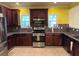 Modern kitchen with stainless steel appliances, granite countertops, and dark wood cabinets at 4312 Defoors Farm Trl, Powder Springs, GA 30127