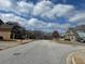 View of the street lined with houses and manicured lawns under a cloudy sky at 4312 Defoors Farm Trl, Powder Springs, GA 30127