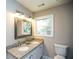 Bright bathroom with double sinks, granite countertops, framed mirror, and natural light at 455 Dollar Mill Sw Rd, Atlanta, GA 30331