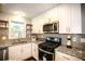 Modern kitchen featuring granite countertops, stainless steel appliances, and white cabinets at 455 Dollar Mill Sw Rd, Atlanta, GA 30331