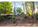 Wooded backyard with mature trees viewed from below the house promoting a natural setting at 1421 Eryn Cir, Suwanee, GA 30024