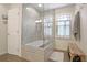 Modern bathroom with glass-enclosed shower/tub, wood-look tile floors, and a clean, bright feel at 1421 Eryn Cir, Suwanee, GA 30024