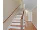 A staircase features hardwood steps, a wood banister, and neutral-colored walls at 1421 Eryn Cir, Suwanee, GA 30024