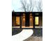 Home entrance with vertical wood siding, black trim, modern lighting, and concrete pathway at 2649 Sunrise Ne Dr, Atlanta, GA 30345