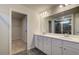 Bright bathroom showcasing a double vanity with white cabinets, a large mirror, and a tiled shower in the background at 108 Dalston Cv, Stockbridge, GA 30281