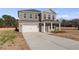 Inviting two-story brick home with a two-car garage, manicured lawn, and long freshly poured concrete driveway at 108 Dalston Cv, Stockbridge, GA 30281