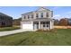 Beautiful new construction with a two-car garage, manicured lawn, freshly poured driveway, and attractive blue door at 108 Dalston Cv, Stockbridge, GA 30281