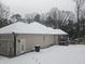 Beige home with covered patio, garage, and snow-covered roof during the winter at 332 Mount Zion Rd, Oxford, GA 30054