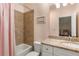 Cozy bathroom featuring a bathtub, tiled walls, and a vanity with granite countertop at 5650 Copper Creek Pass, Cumming, GA 30040