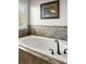 Large white bathtub with bronze fixtures and tile surround at 5650 Copper Creek Pass, Cumming, GA 30040