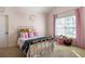 Charming pink bedroom with carpet, large window, decorative butterfly mobile and gold metal bedframe at 5650 Copper Creek Pass, Cumming, GA 30040