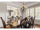 Elegant dining room features a large window with plantation shutters and a spacious wooden table with seating for eight at 5650 Copper Creek Pass, Cumming, GA 30040