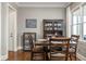 Bright dining room featuring hardwood floors, dark wood furniture, and a large window at 5650 Copper Creek Pass, Cumming, GA 30040