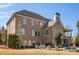 Back exterior of a large brick home with a covered deck and a lawn area at 5650 Copper Creek Pass, Cumming, GA 30040