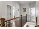 Hallway with wood and iron railing and neutral paint at 5650 Copper Creek Pass, Cumming, GA 30040