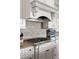 Close-up of kitchen featuring a range hood, gas cooktop, and granite countertops with tiled backsplash at 5650 Copper Creek Pass, Cumming, GA 30040