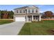 Inviting two-story brick home featuring a well-manicured lawn, covered entryway, attached two-car garage, and landscaped front yard at 120 Dalston Cv, Stockbridge, GA 30281