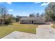 View of the back of the home, a spacious lawn, a long driveway, and mature trees at 1901 Lullwater Cir, Jonesboro, GA 30236