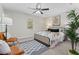 The bright main bedroom features a ceiling fan, a neutral palette, and contemporary furnishings at 1901 Lullwater Cir, Jonesboro, GA 30236