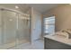 Bathroom featuring a glass enclosed shower, double sink vanity with gray cabinetry and granite counters at 208 Chiswick Loop, Stockbridge, GA 30281