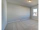 Neutral bedroom with a beige carpet and bright natural light from the window at 208 Chiswick Loop, Stockbridge, GA 30281