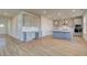 Well-lit kitchen with gray cabinets, an island with a white countertop, and hardwood flooring at 208 Chiswick Loop, Stockbridge, GA 30281