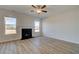 Inviting living room featuring a fireplace, light wood floors, and ample natural light from two windows at 208 Chiswick Loop, Stockbridge, GA 30281