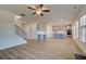 Bright open-concept living room and kitchen with hardwood floors and a modern ceiling fan at 208 Chiswick Loop, Stockbridge, GA 30281