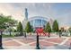 Exterior view of City Hall with manicured landscaping and public art in a brick-paved plaza at 3908 Charleston Market St, Suwanee, GA 30024