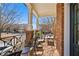 Inviting front porch featuring a seating area with iron railing, brick flooring, and classic white pillars at 3908 Charleston Market St, Suwanee, GA 30024