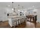 Bright and airy kitchen featuring white cabinetry, stainless steel appliances, and a large center island with bar seating at 3908 Charleston Market St, Suwanee, GA 30024