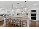 Open-concept kitchen featuring stainless steel appliances, a center island with barstool seating, and hardwood flooring at 3908 Charleston Market St, Suwanee, GA 30024