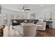 Spacious living room featuring hardwood floors, a black leather sofa, and abundant natural light at 3908 Charleston Market St, Suwanee, GA 30024