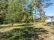 Spacious backyard with mature trees providing ample shade on a sunny day at 724 Se Cowan Se Rd, Conyers, GA 30094