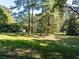 Lush backyard area with towering trees, creates a private and serene outdoor space at 724 Se Cowan Se Rd, Conyers, GA 30094