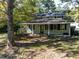 Two-story house with a covered porch, black shutters, and a natural setting surrounded by trees at 724 Se Cowan Se Rd, Conyers, GA 30094