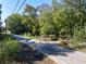 Street view of the home with mature trees, white fence, and a long driveway leading to the house at 724 Se Cowan Se Rd, Conyers, GA 30094